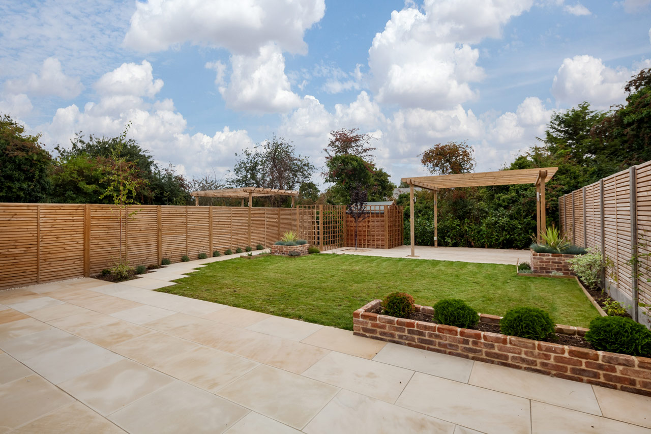 Beautifully landscaped backyard with pergola and manicured lawn by ParrotWerks Construction